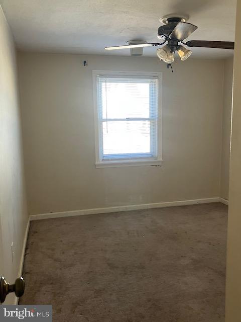 carpeted empty room featuring ceiling fan