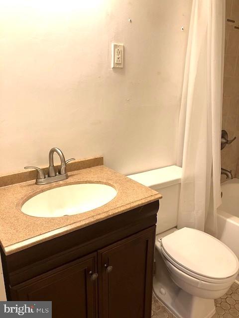 full bathroom with vanity, shower / bath combination with curtain, and toilet