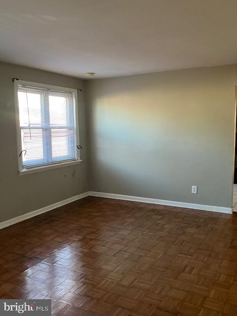 empty room featuring dark parquet flooring