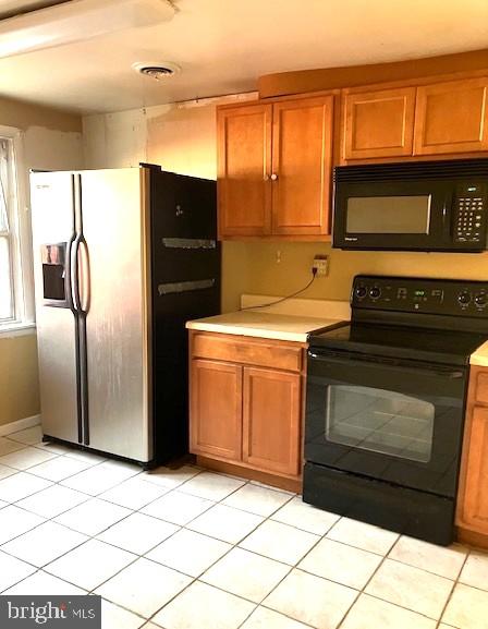 kitchen featuring light tile patterned floors and black appliances