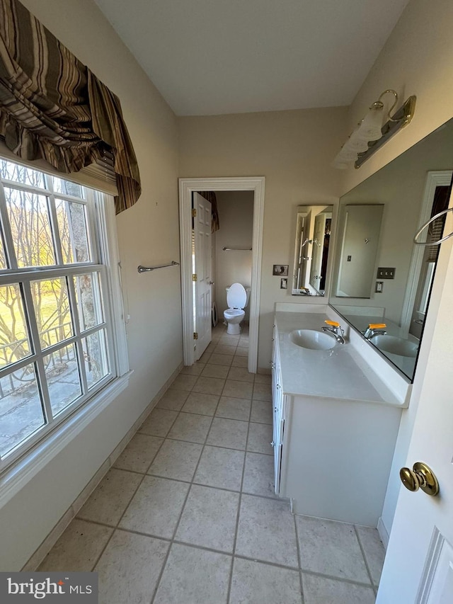 bathroom featuring vanity, plenty of natural light, and toilet