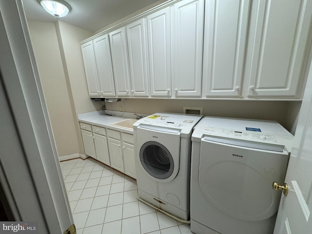 clothes washing area with separate washer and dryer, sink, cabinets, and light tile patterned flooring