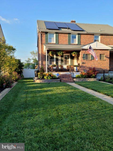 view of front of property featuring a front yard and solar panels