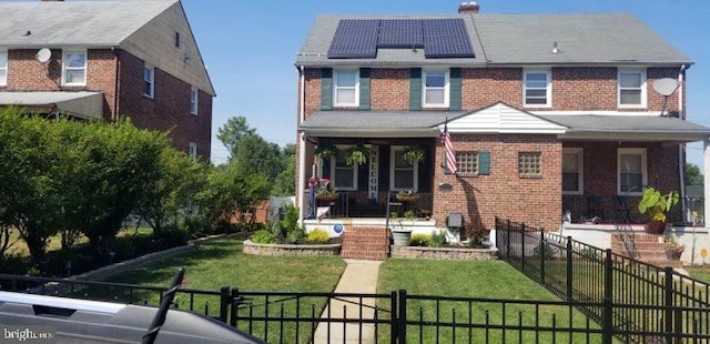 back of property featuring a yard, covered porch, and solar panels