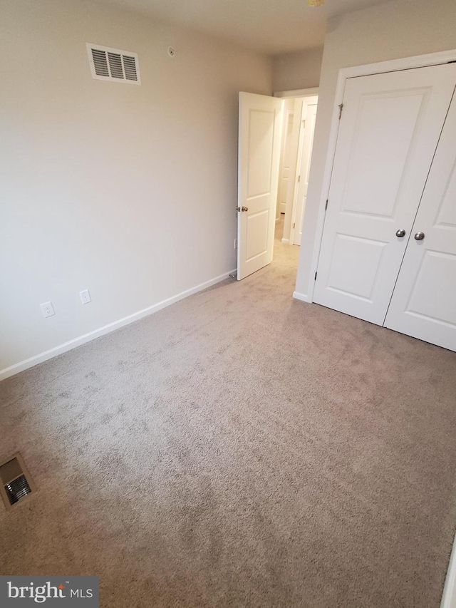 unfurnished bedroom featuring carpet flooring and a closet