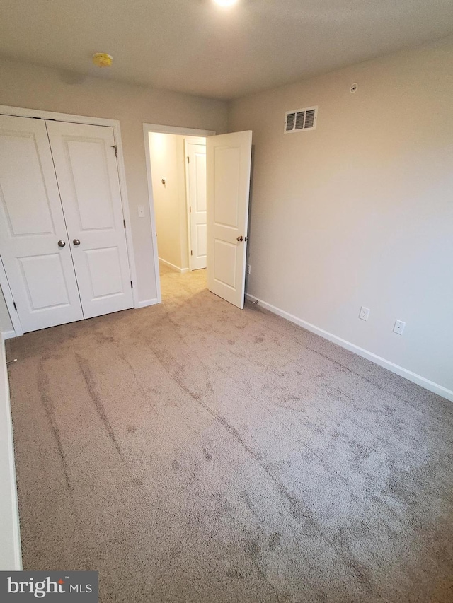 unfurnished bedroom featuring carpet flooring and a closet