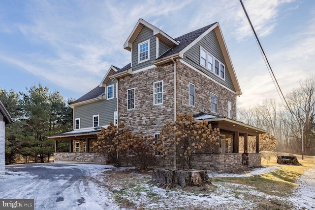 snow covered property with covered porch