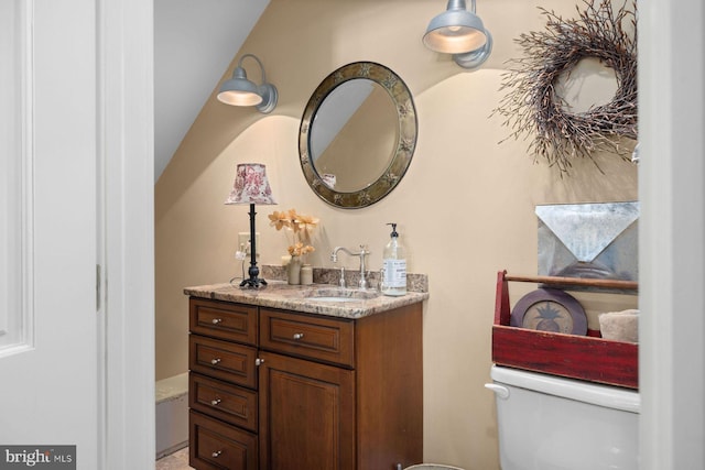 bathroom with lofted ceiling, vanity, and toilet