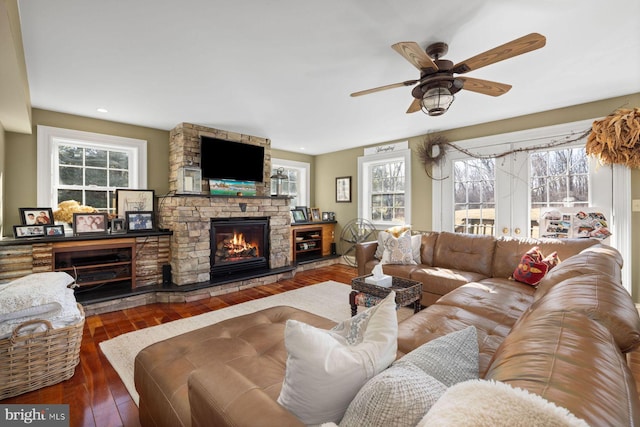 living room with a wealth of natural light, a fireplace, and dark hardwood / wood-style floors