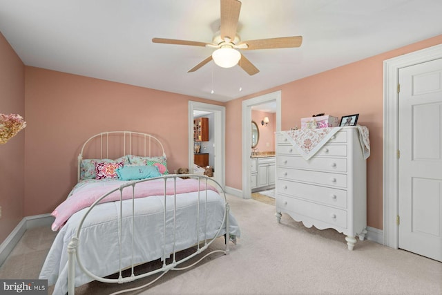 bedroom with ceiling fan, light carpet, and ensuite bath