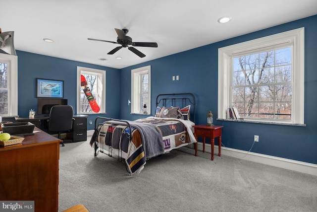 bedroom with ceiling fan, carpet floors, and multiple windows