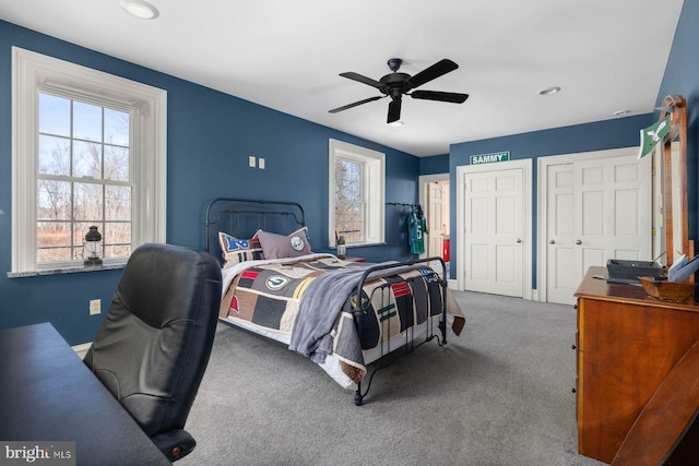 carpeted bedroom featuring two closets and ceiling fan