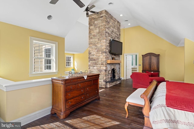 bedroom with lofted ceiling, dark hardwood / wood-style flooring, and a stone fireplace