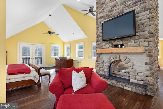 bedroom featuring access to exterior, dark hardwood / wood-style floors, a stone fireplace, and french doors