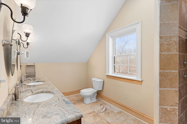 bathroom featuring vanity, lofted ceiling, and toilet