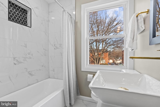 bathroom featuring a wealth of natural light, sink, and shower / tub combo