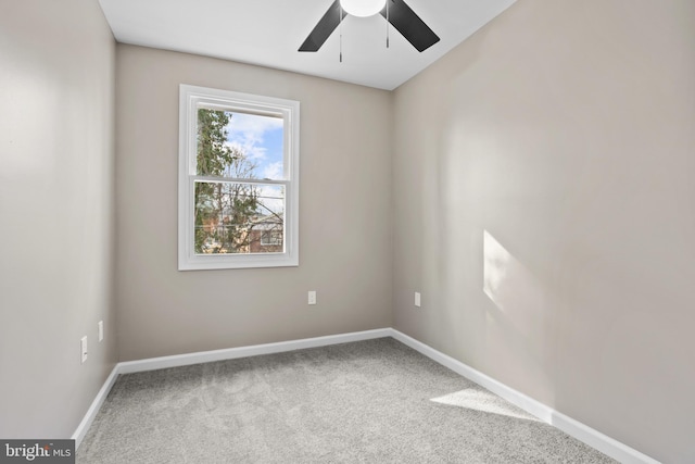 carpeted spare room featuring ceiling fan