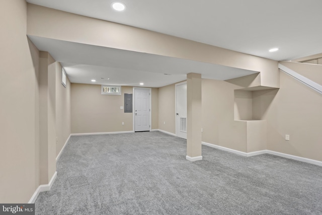 basement with electric panel and light colored carpet