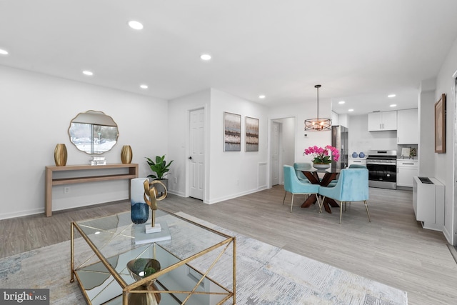 living room featuring radiator heating unit and light hardwood / wood-style flooring