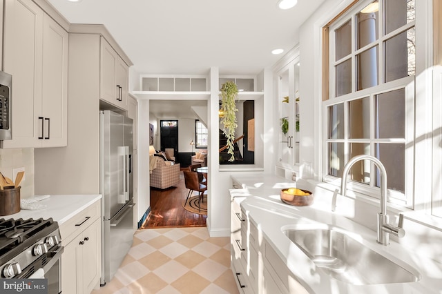 kitchen with light stone counters, appliances with stainless steel finishes, and sink