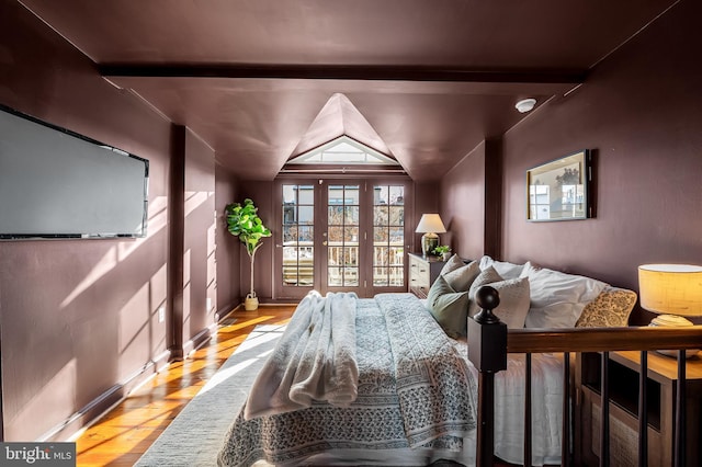 bedroom featuring light hardwood / wood-style flooring and lofted ceiling