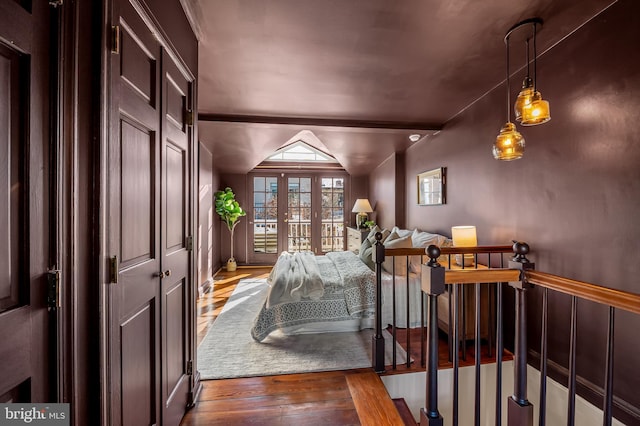 bedroom with french doors, dark hardwood / wood-style flooring, and vaulted ceiling with beams