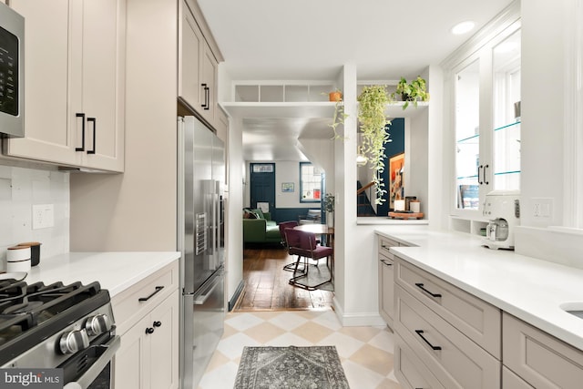 kitchen with backsplash, plenty of natural light, and appliances with stainless steel finishes