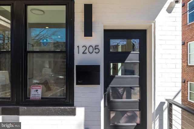 view of exterior entry with brick siding