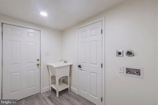 laundry room with hookup for a washing machine, light hardwood / wood-style floors, and hookup for an electric dryer