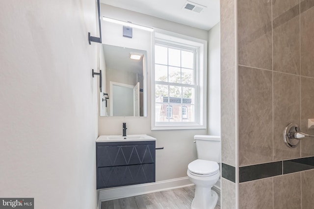 bathroom with vanity, toilet, and wood-type flooring