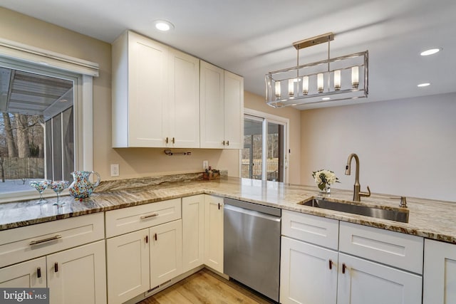 kitchen featuring sink, hanging light fixtures, stainless steel dishwasher, light stone counters, and kitchen peninsula