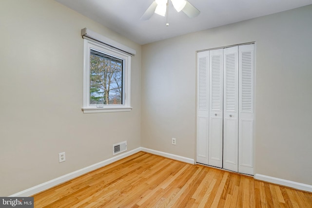 unfurnished bedroom featuring ceiling fan, a closet, and light hardwood / wood-style flooring