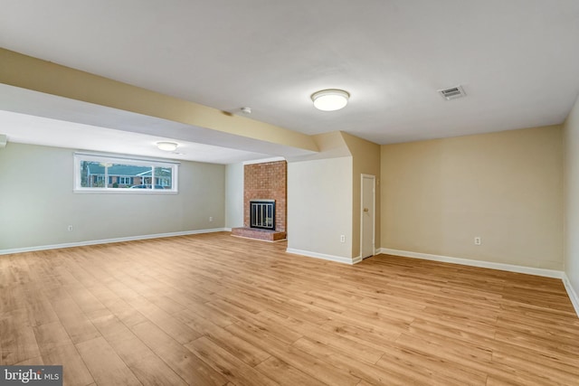 unfurnished living room with a fireplace and light hardwood / wood-style floors