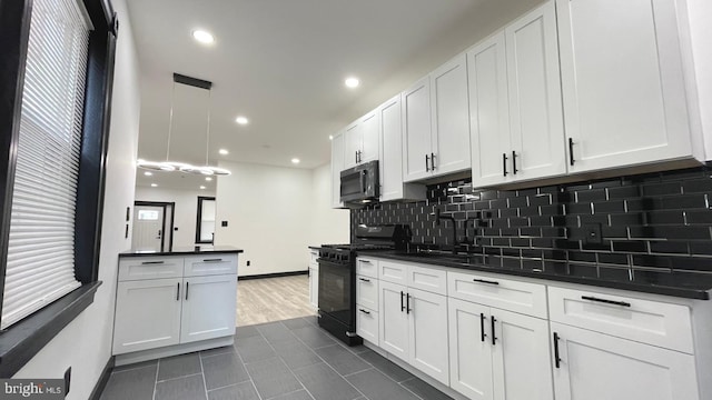 kitchen with black gas range, sink, decorative light fixtures, white cabinets, and dark tile patterned flooring