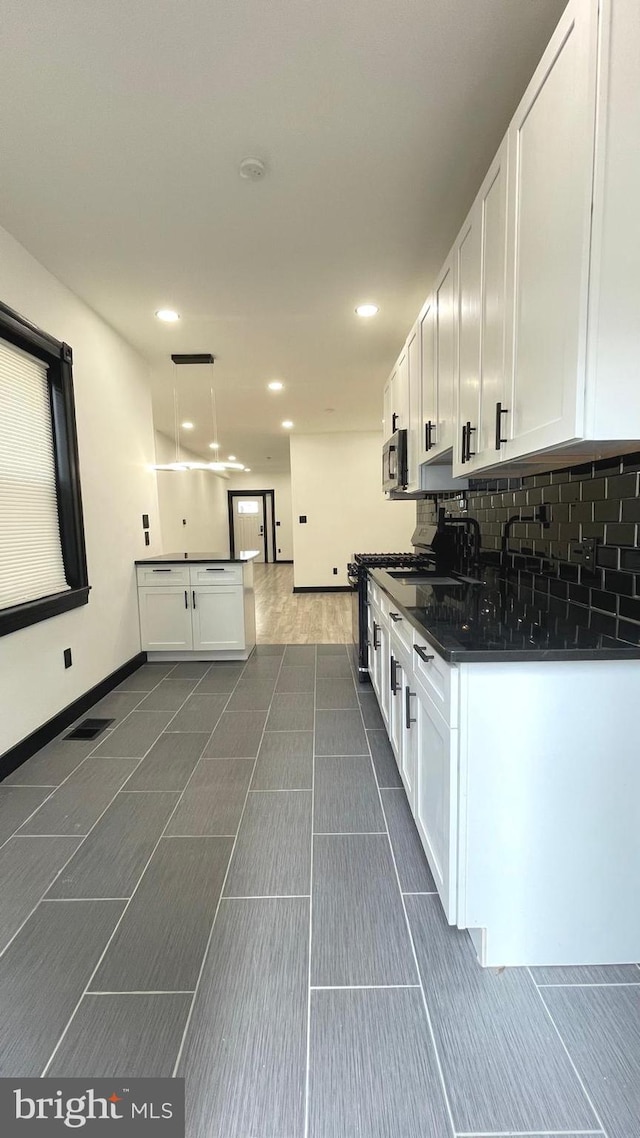 kitchen featuring decorative backsplash, white cabinetry, and pendant lighting