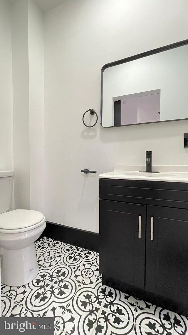 bathroom featuring tile patterned flooring, vanity, and toilet