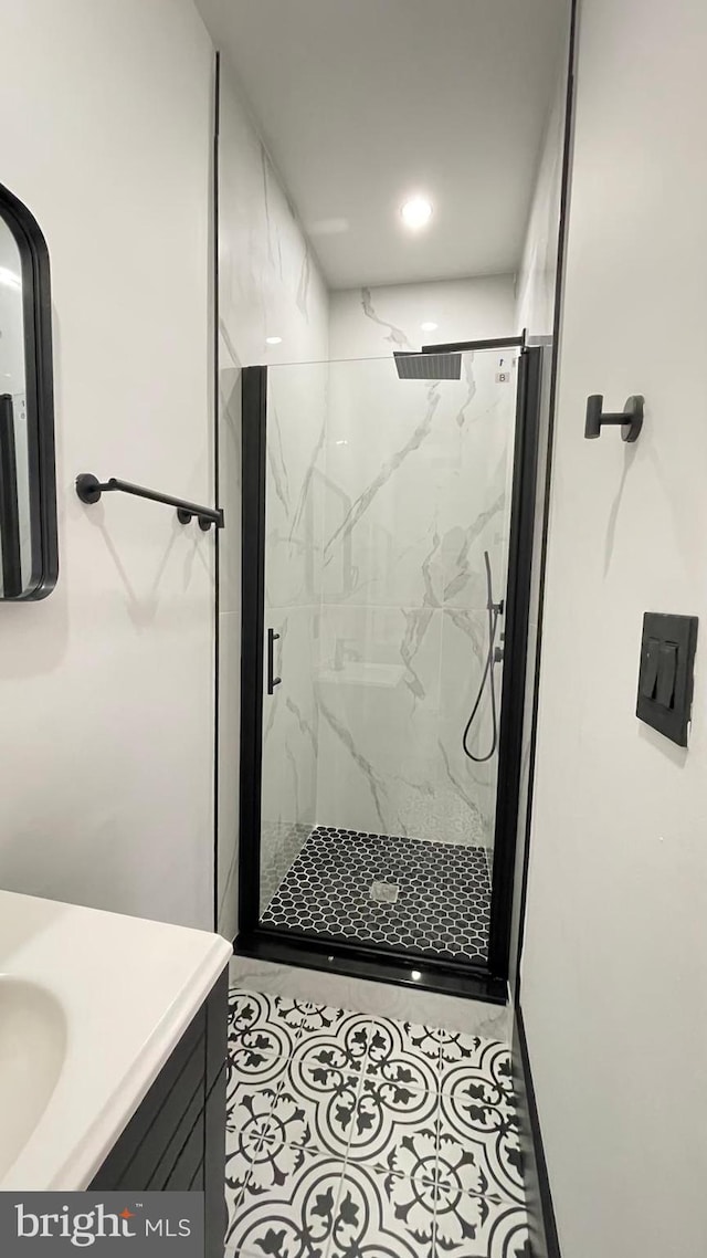 bathroom with tile patterned floors, vanity, and walk in shower