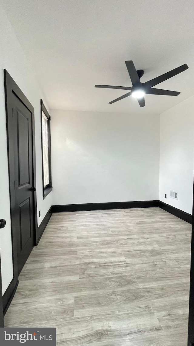 unfurnished room with light wood-type flooring and ceiling fan