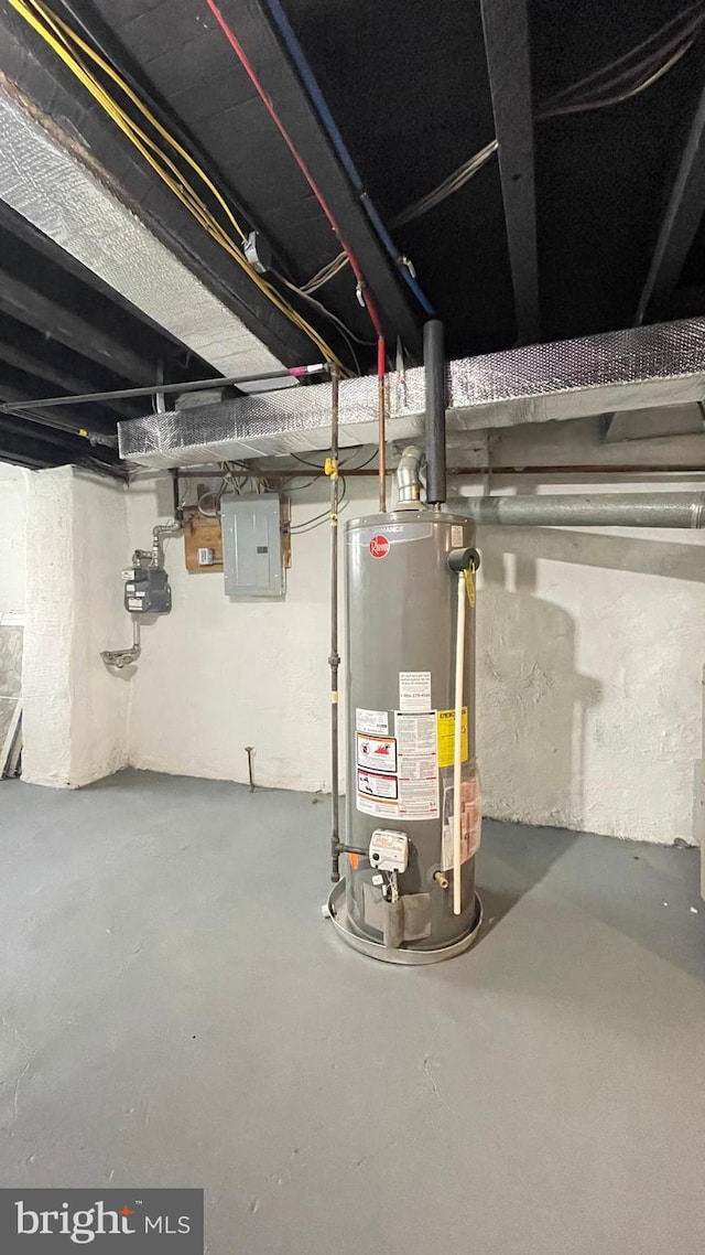 basement featuring electric panel and water heater