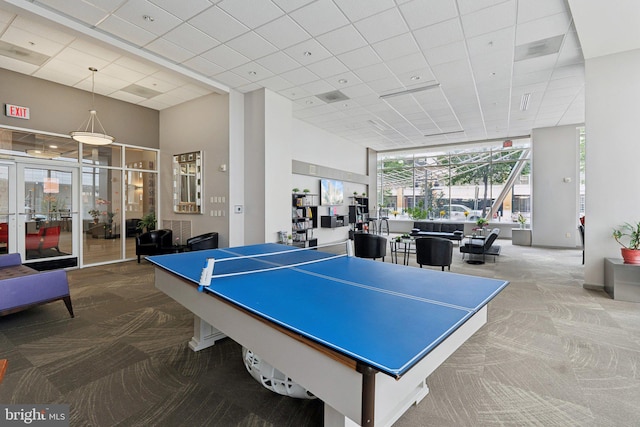 rec room featuring carpet flooring, a drop ceiling, and french doors