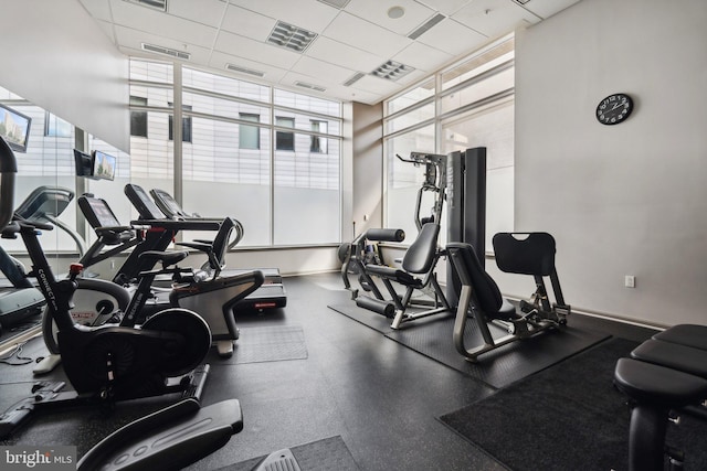 exercise room with a wealth of natural light and a drop ceiling