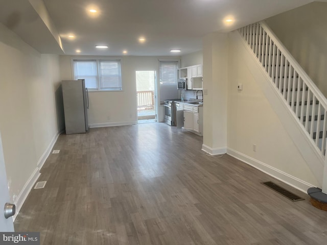 unfurnished living room with dark hardwood / wood-style flooring and sink