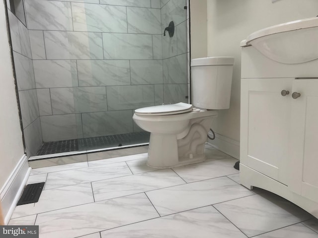 bathroom with tiled shower, vanity, and toilet