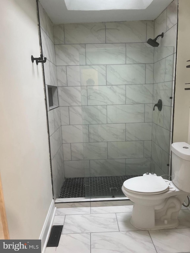 bathroom with tiled shower and toilet