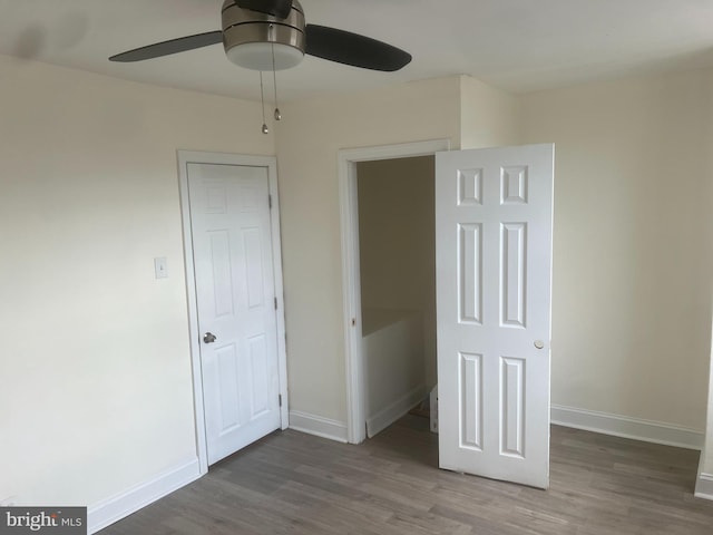 unfurnished bedroom featuring ceiling fan, dark wood-type flooring, and a closet