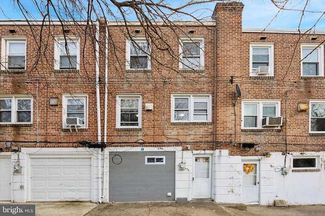 view of front of property featuring cooling unit and a garage