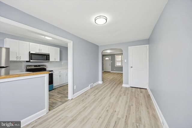 kitchen with white cabinetry, light hardwood / wood-style flooring, and appliances with stainless steel finishes