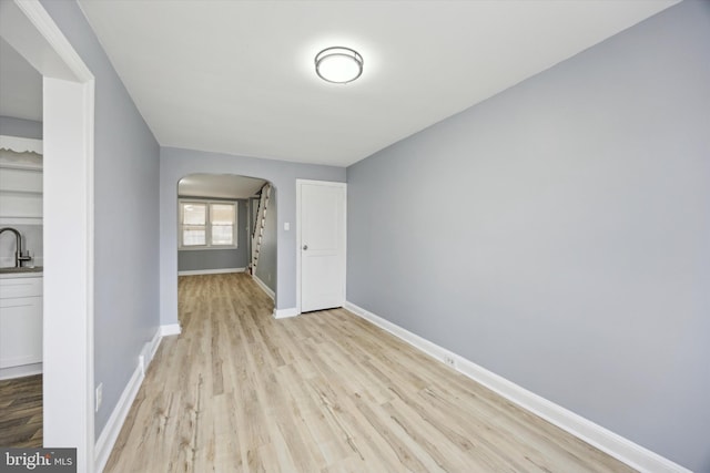 unfurnished room with light hardwood / wood-style floors and sink