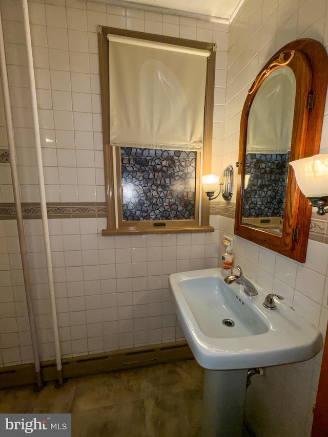 bathroom featuring sink and tile walls