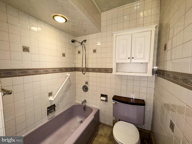 bathroom featuring washtub / shower combination, tile patterned floors, toilet, and tile walls